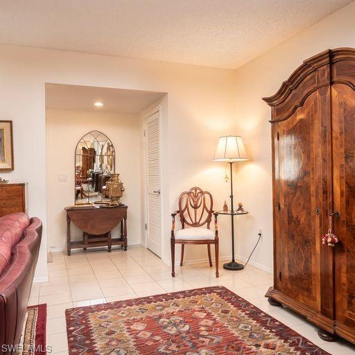 760 Willowbrook Drive, Unit 1202 Naples, FL 34108 - Photo 4 of 28 a living room with furniture a rug and a painting on the wall