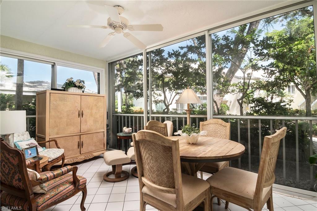 760 Willowbrook Drive, Unit 1202 Naples, FL 34108 - Photo 7 of 28 a dining room with furniture a chandelier and wooden floor