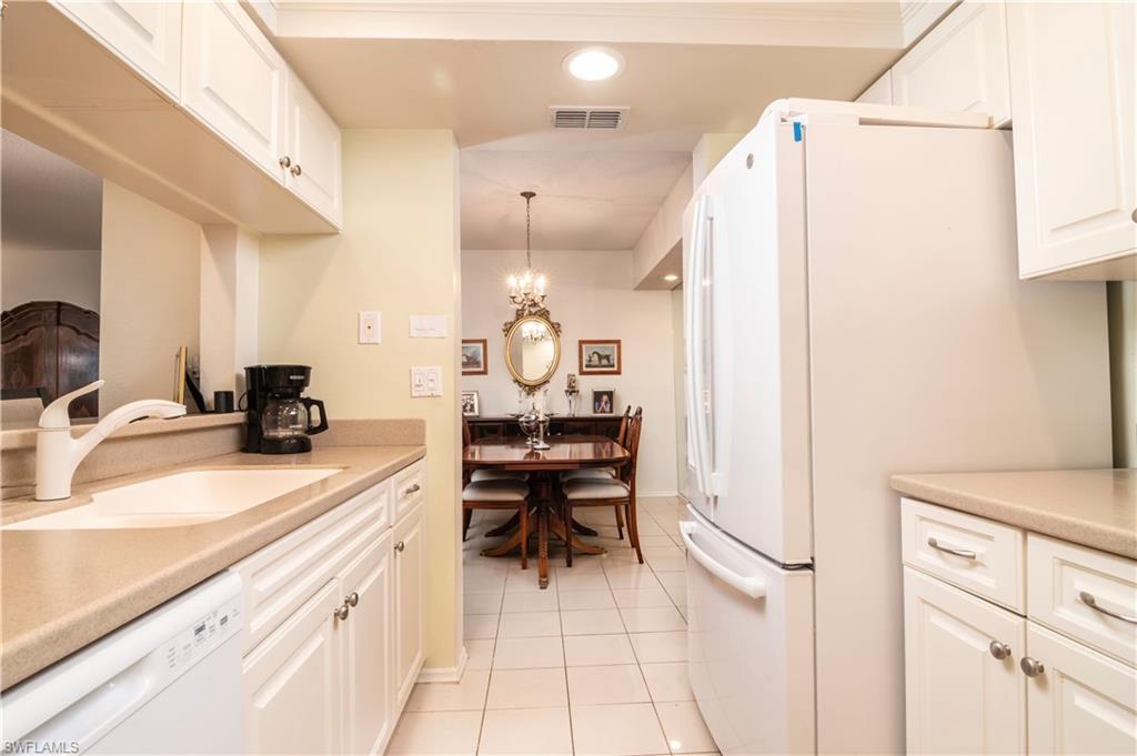 760 Willowbrook Drive, Unit 1202 Naples, FL 34108 - Photo 10 of 28 a kitchen with a sink appliances and cabinets