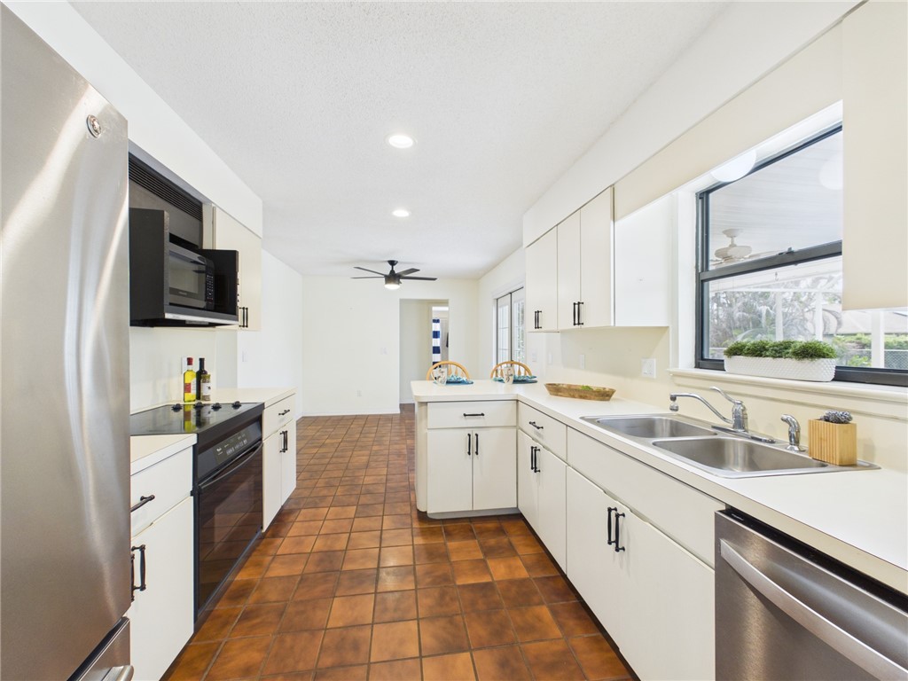 225 Midvale Terrace Sebastian, FL 32958 - Photo 10 of 25 a large kitchen with a sink and a stove top oven