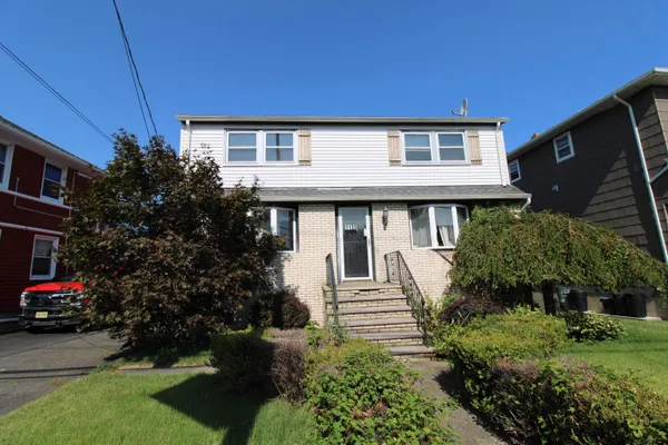 a front view of a house with a garden