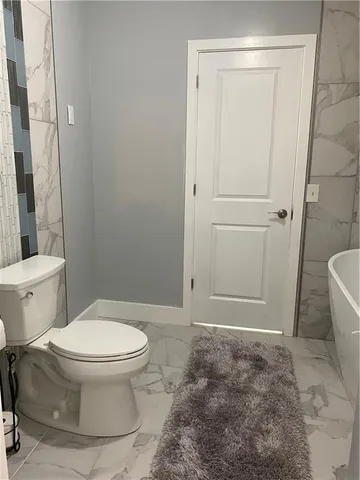 a white toilet sitting next to a bathroom sink