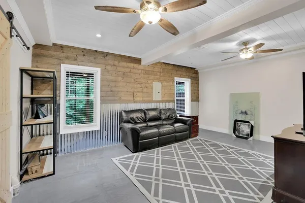 a living room with furniture a ceiling fan and a window