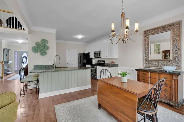 a kitchen with a table chairs sink and cabinets