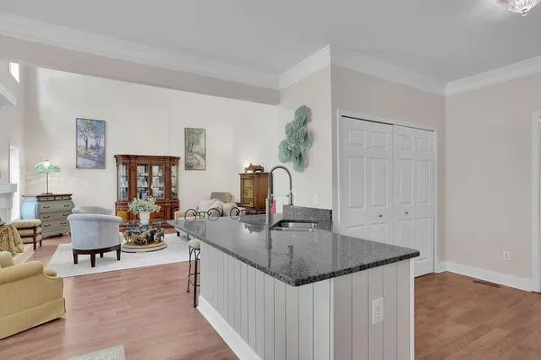 a kitchen with granite countertop a sink and white cabinets