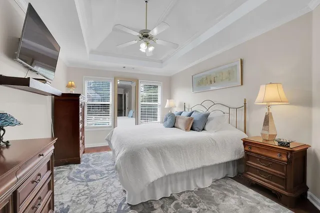 a bedroom with a bed and a flat tv screen on dresser