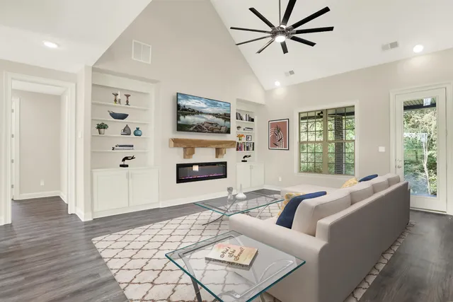 a large kitchen with white cabinets stainless steel appliances and wooden floor