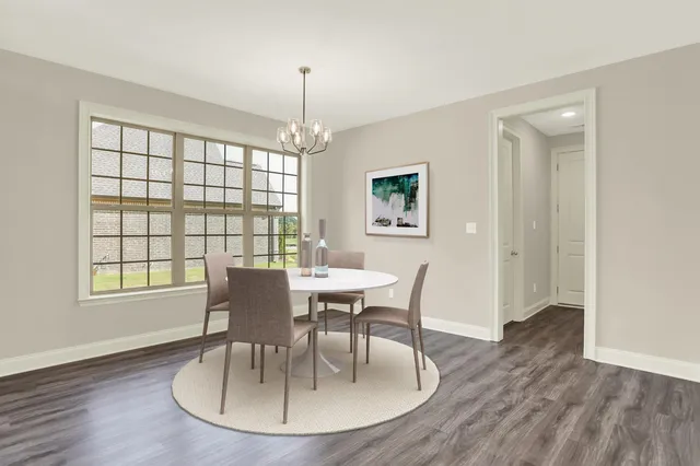 a view of an empty room with kitchen and window