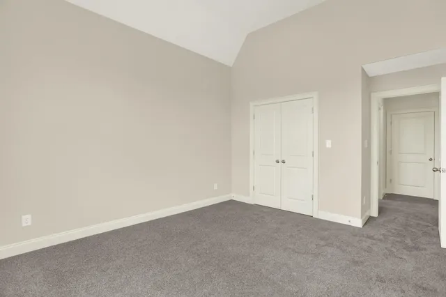 an empty room with closet and a ceiling fan