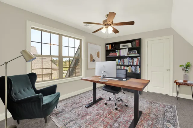 a living room with furniture a bookshelf and a large window