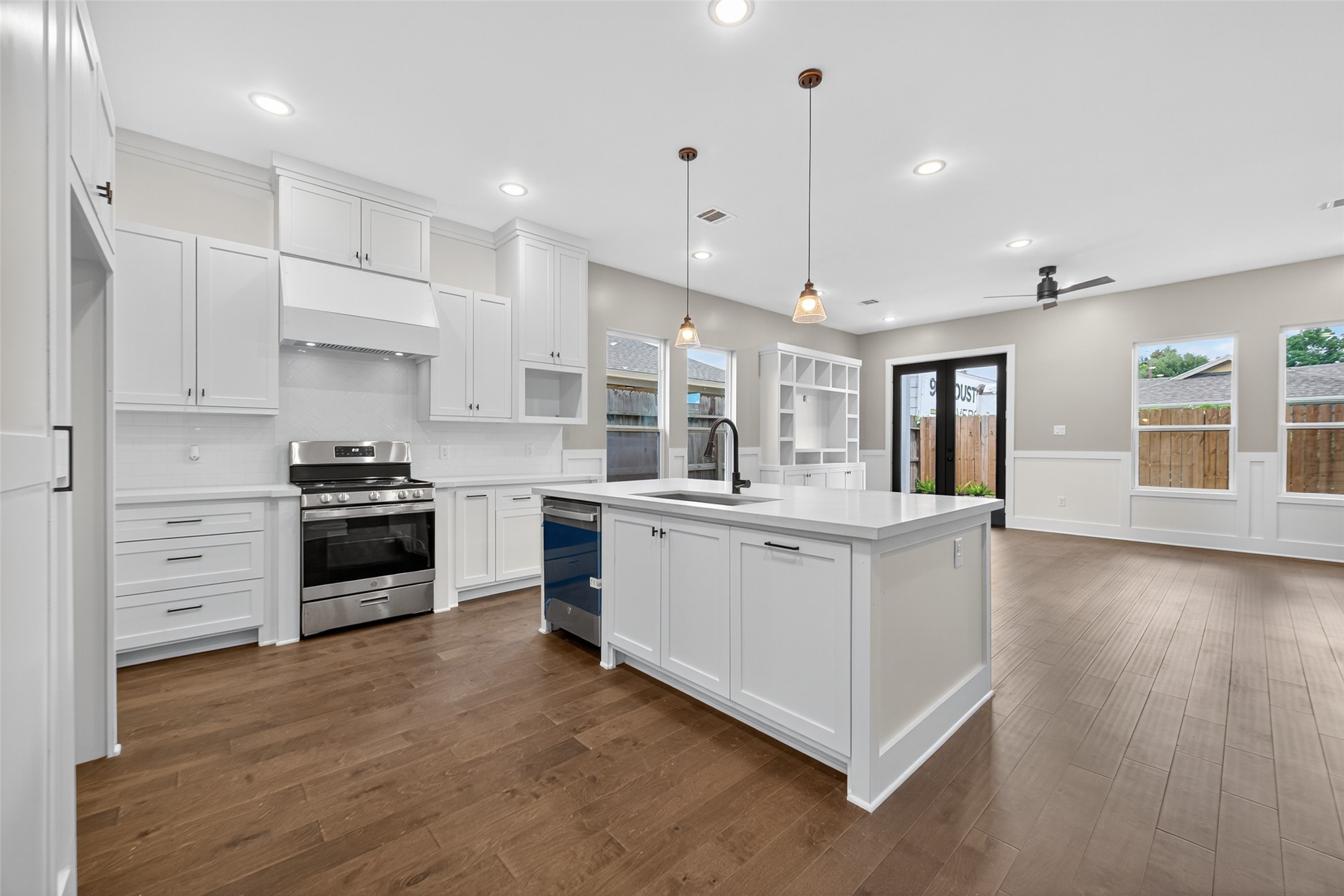 7325 Market Street Houston, TX 77020 - Photo 8 of 47 a kitchen with stainless steel appliances white cabinets and wooden floors