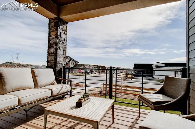 a roof deck with couches and potted plants with sky view