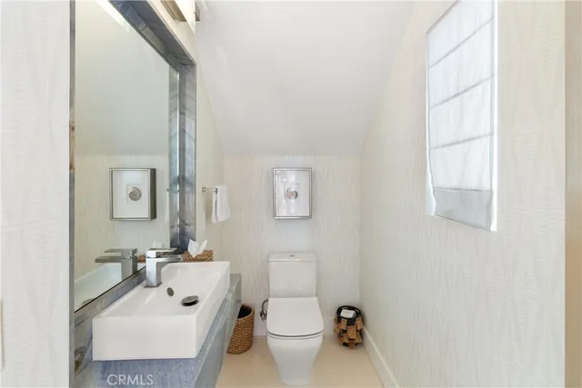 a bathroom with a sink toilet and a mirror