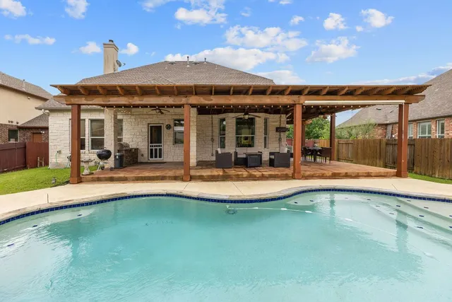 a view of a house with swimming pool and sitting area