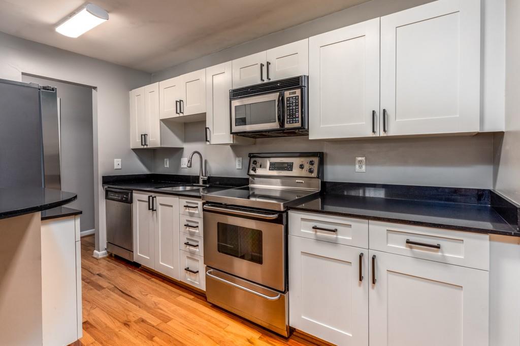 3501 Roswell Road Northeast, Unit 103 Atlanta, GA 30305 - Photo 6 of 13 a kitchen with white cabinets stainless steel appliances and sink