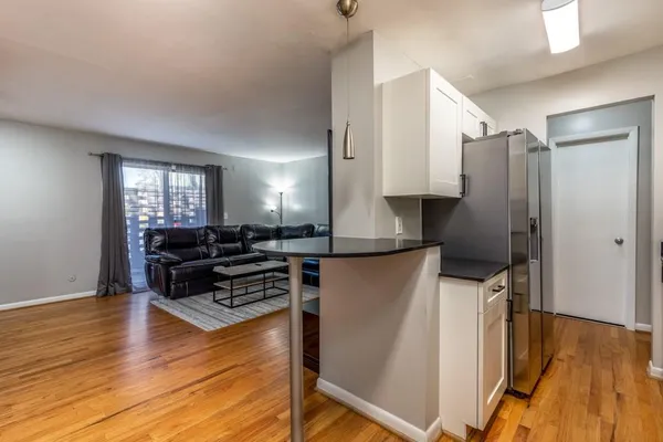 a kitchen with stainless steel appliances a refrigerator and wooden floor
