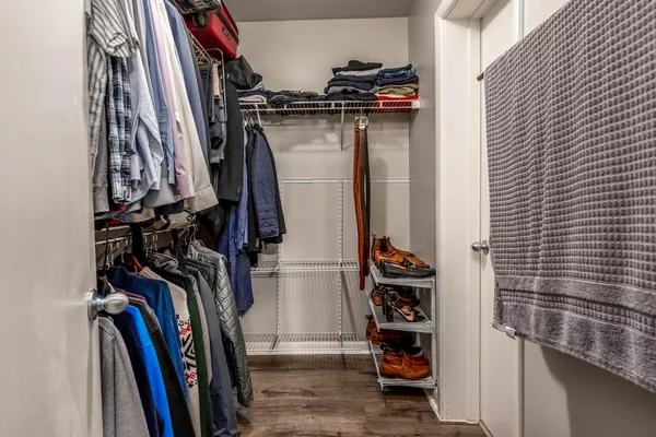 a view of walk in closet with clothes and shoes