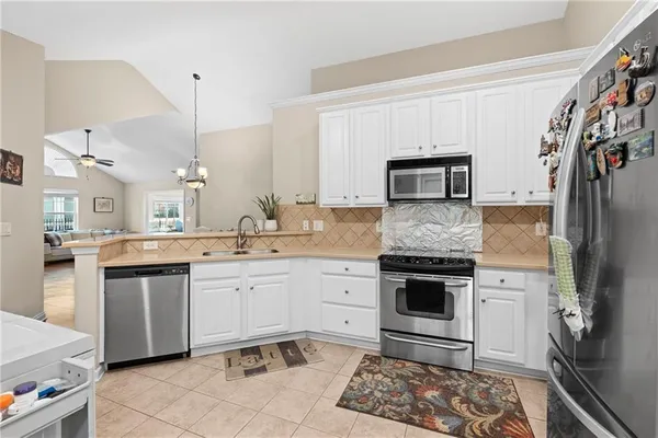 a kitchen with stainless steel appliances granite countertop a stove a sink and a refrigerator