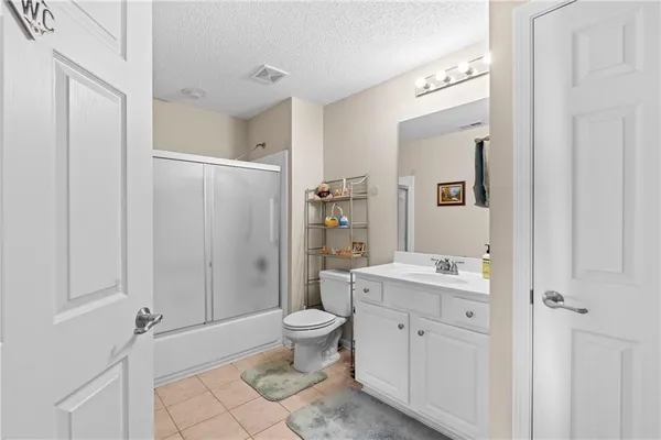 a spacious bathroom with a granite countertop sink toilet and shower