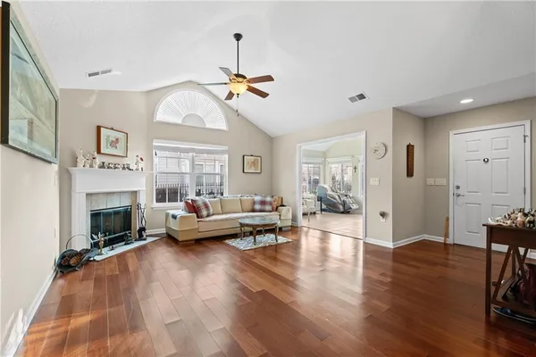 a living room with furniture a fireplace and a chandelier