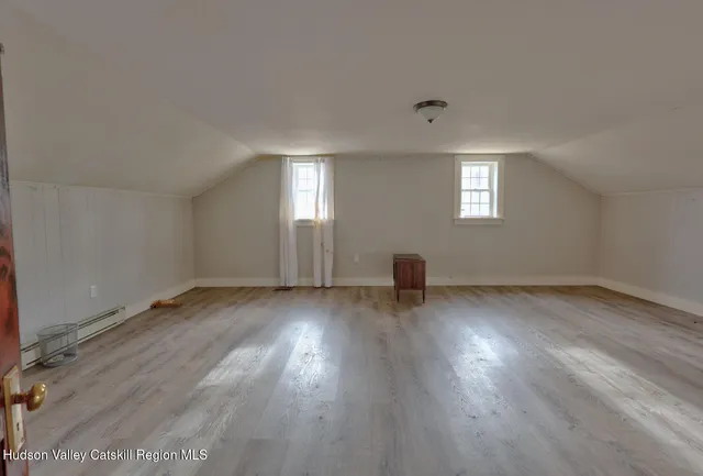 a view of empty room with wooden floor and window