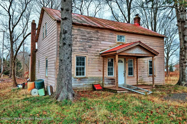 a view of a house with a yard and large tree