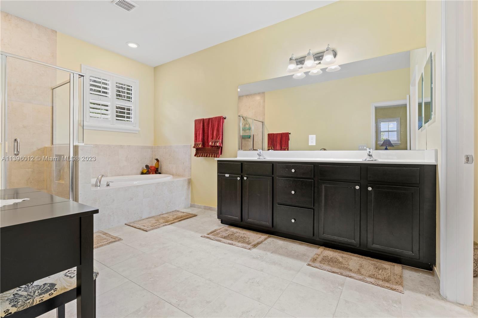 12120 Village Place Davie, FL 33325 - Photo 13 of 35 a spacious bathroom with a granite countertop double vanity sink mirror and bathtub