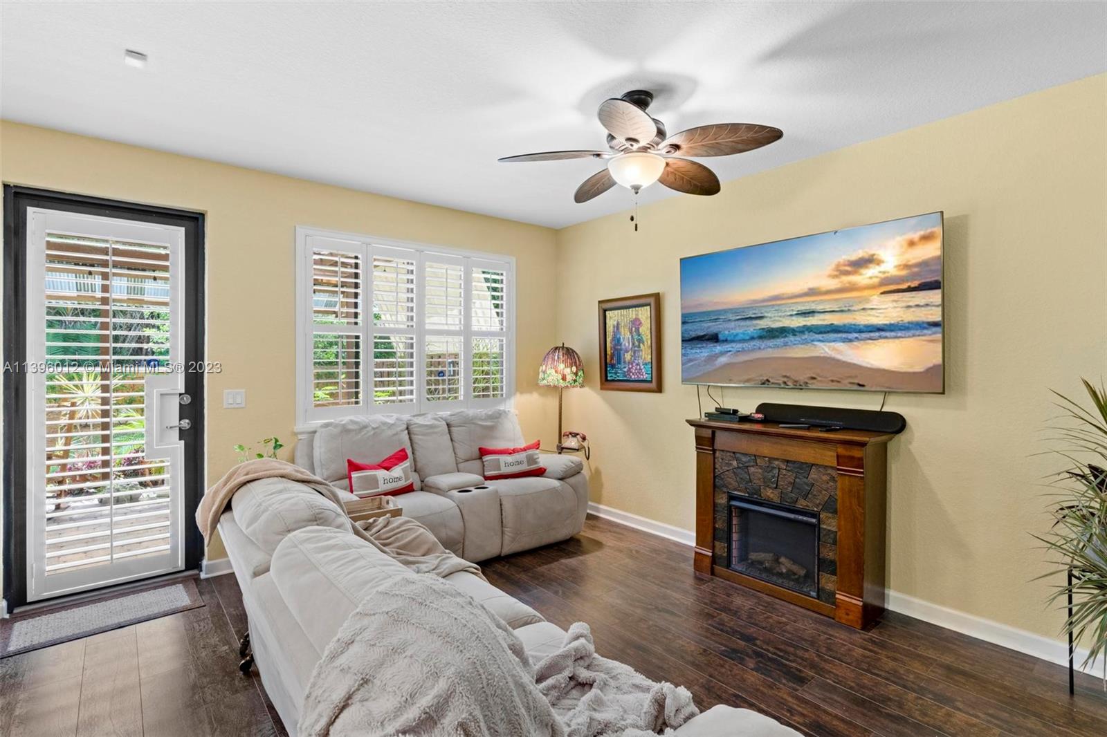 12120 Village Place Davie, FL 33325 - Photo 19 of 35 a living room with furniture a fireplace and a flat screen tv