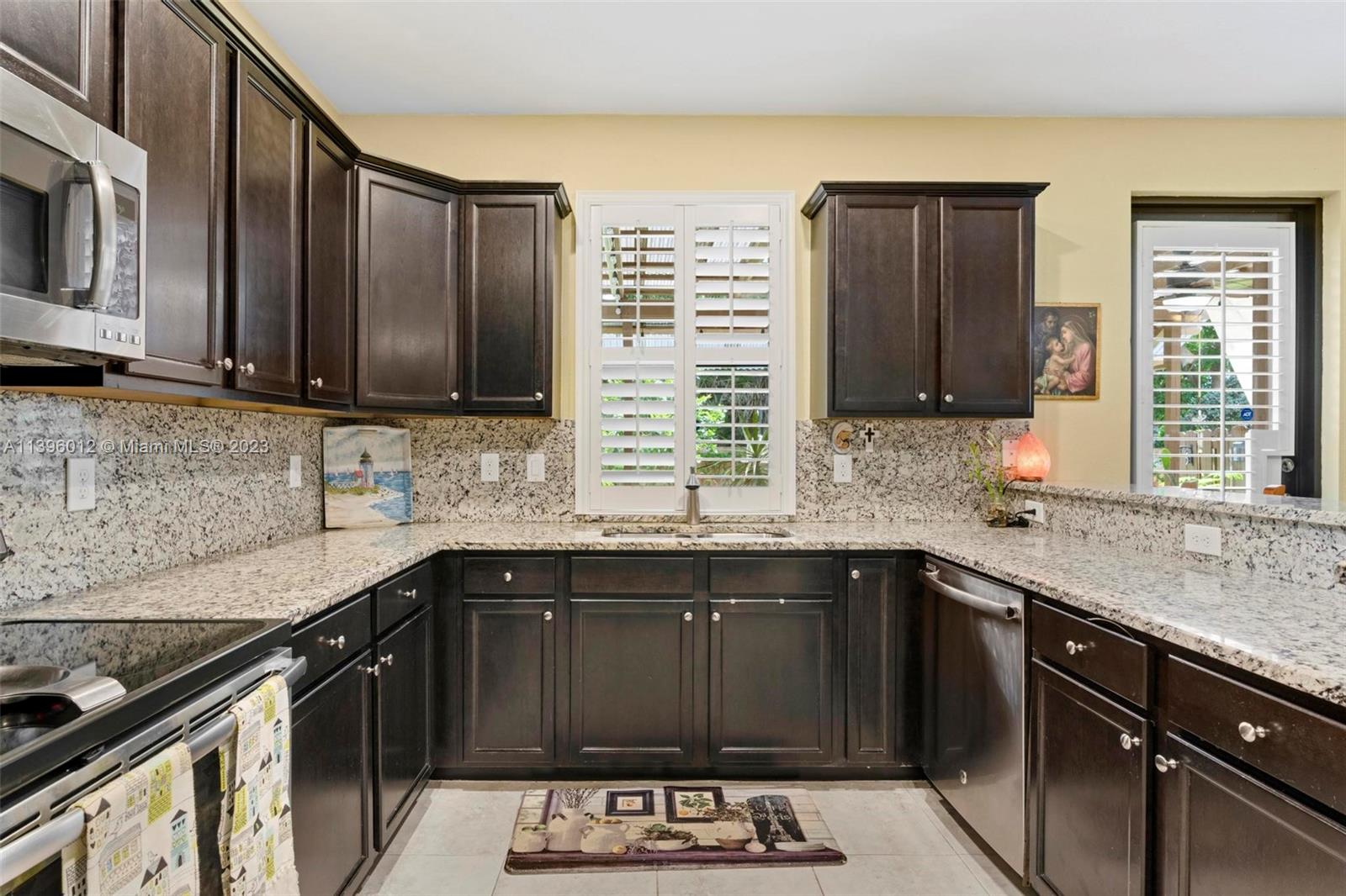 12120 Village Place Davie, FL 33325 - Photo 24 of 35 a kitchen with stainless steel appliances granite countertop a sink stove and microwave