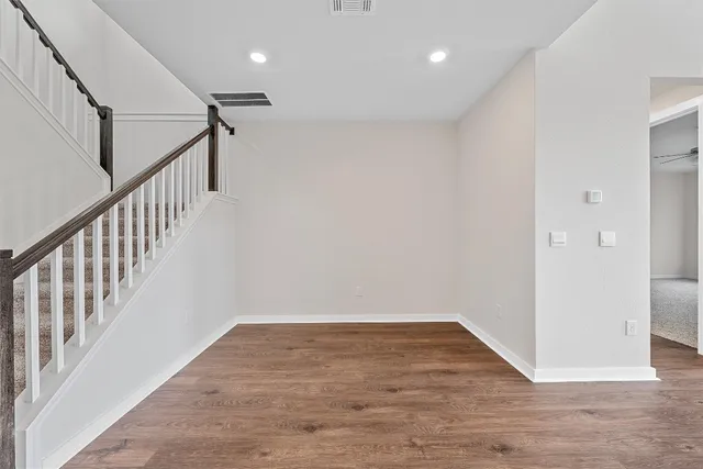 a view of an empty room with wooden floor