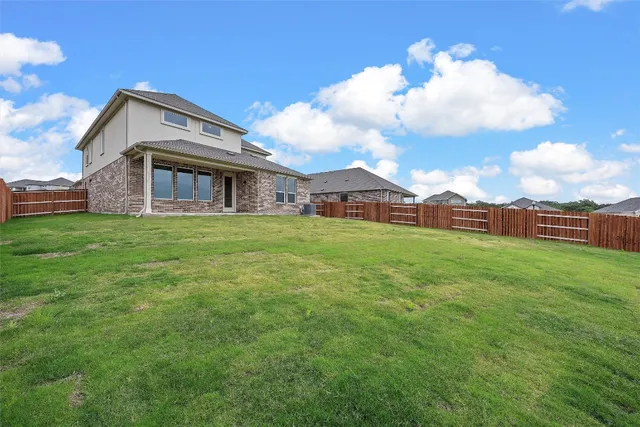 a view of a house with a big yard and large trees