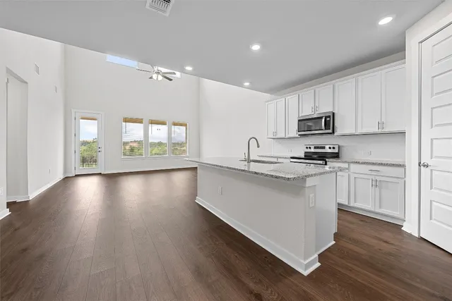 a kitchen with kitchen island white cabinets and wooden floor