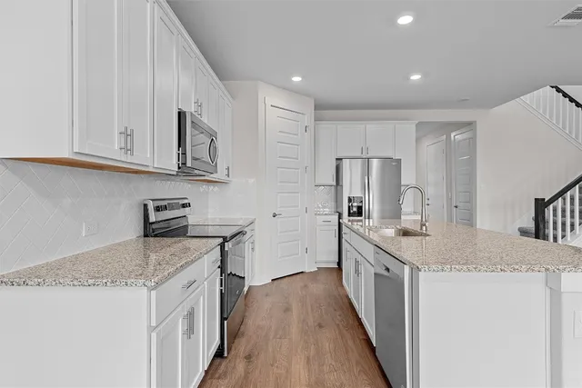 a kitchen with stainless steel appliances granite countertop a sink stove and refrigerator
