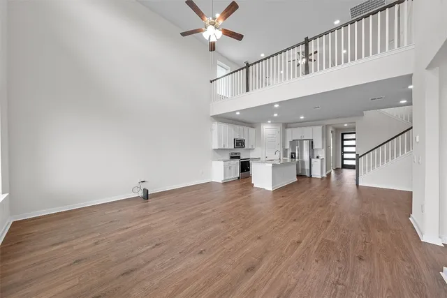 a view of a kitchen with wooden floor and a ceiling fan