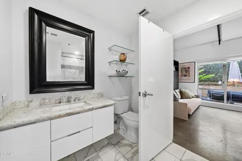 a en suite bathroom with a granite countertop sink and a mirror