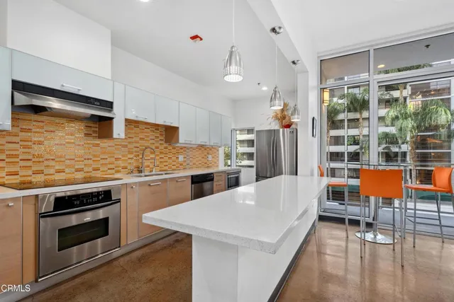 a kitchen with stainless steel appliances kitchen island granite countertop a stove and a sink