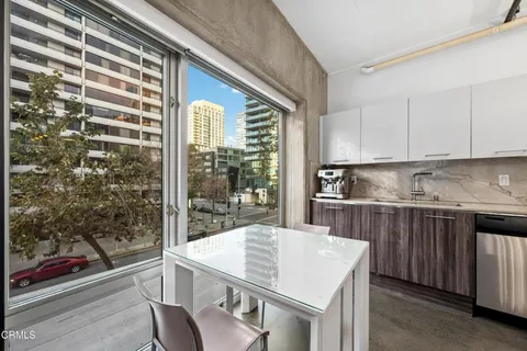 a kitchen with a sink a stove and white cabinets