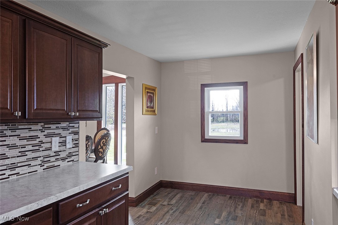 11794 Vermilion Road Oberlin, OH 44074 - Photo 20 of 34 Kitchen featuring dark wood finished floors, light countertops, dark brown cabinets, and tasteful backsplash