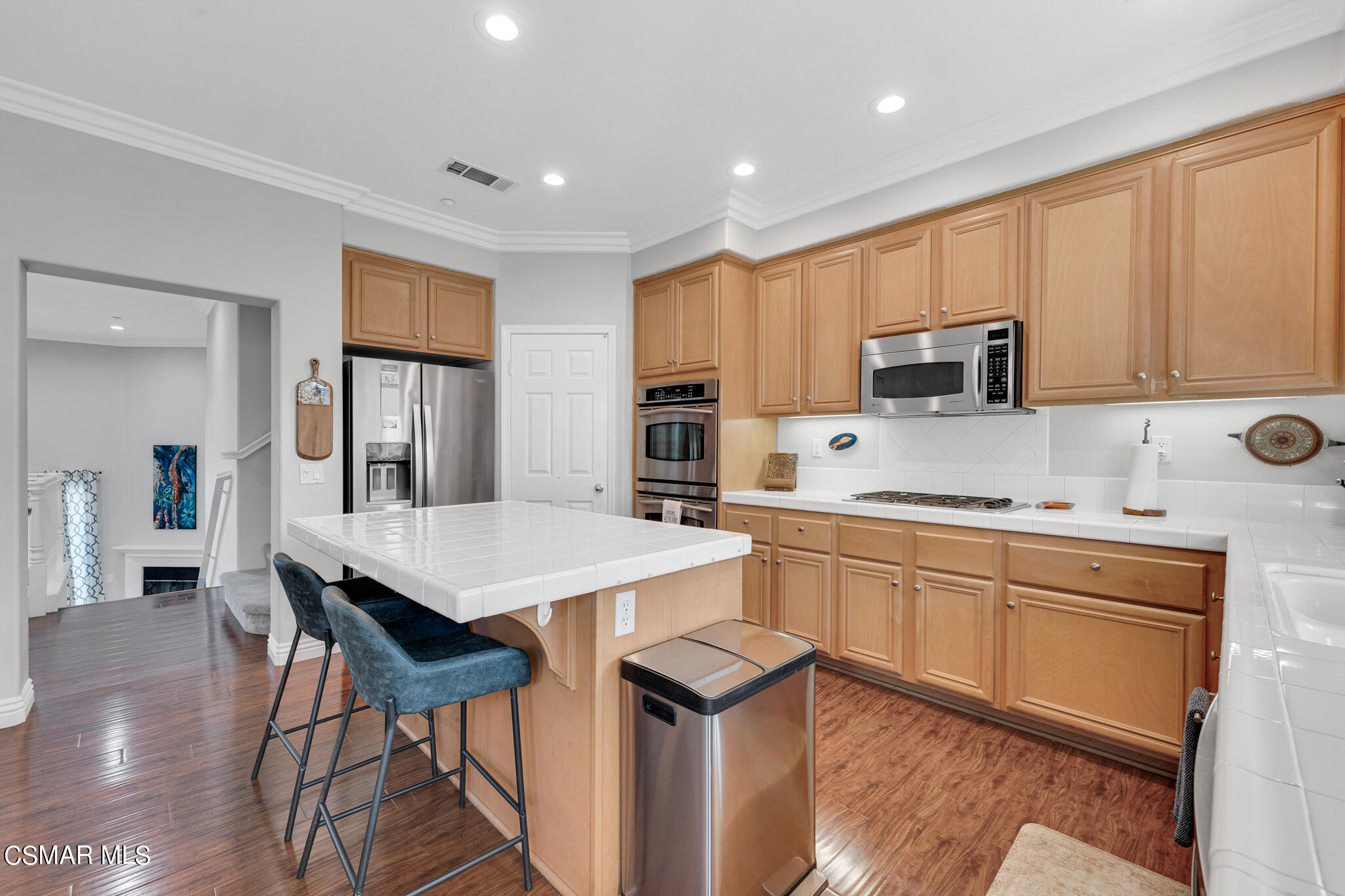 1233 Bayside Circle Oxnard, CA 93035 - Photo 15 of 37 a kitchen with stainless steel appliances granite countertop a stove top oven a sink dishwasher and a refrigerator with wooden floor