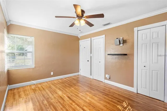a view of a livingroom with a ceiling fan & wooden floor