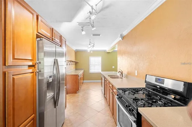 a kitchen with stainless steel appliances granite countertop a sink stove and refrigerator