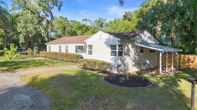 a front view of a house with a yard and potted plants