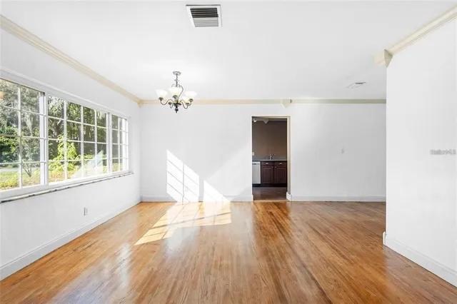 a view of a livingroom with wooden floor and a window
