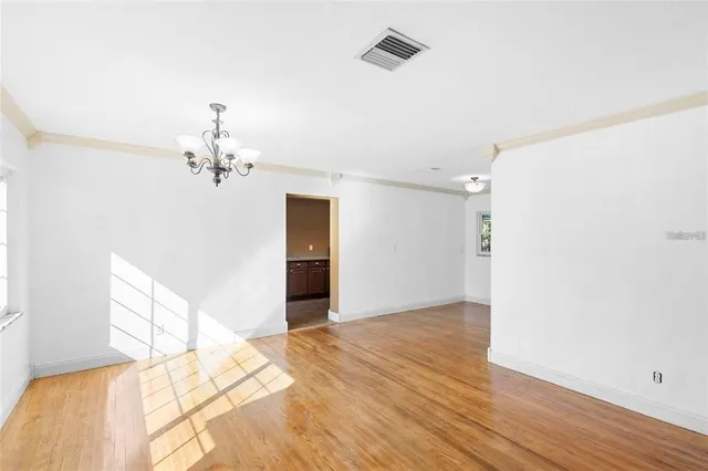 a view of a bedroom with wooden floor and chandelier