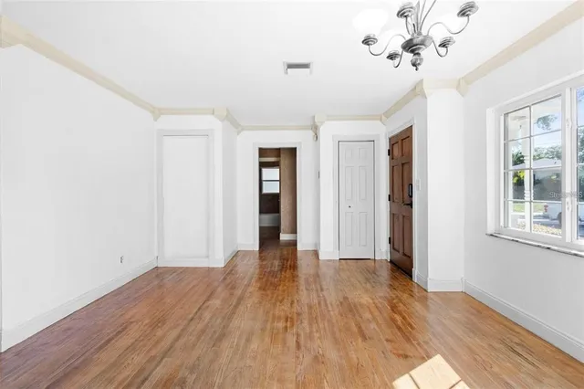 a view of a room with wooden floor and ceiling fan