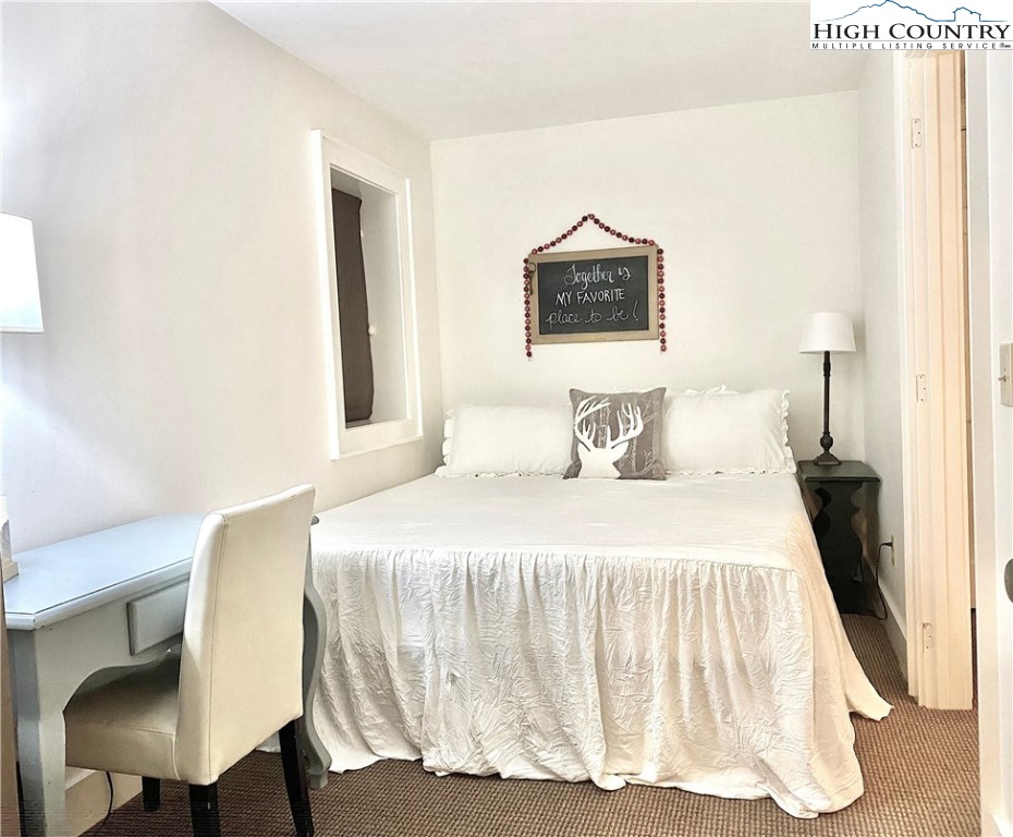 702 Pine Ridge Road Beech Mountain, NC 28604 - Photo 12 of 24 a bedroom with a bed and a chair