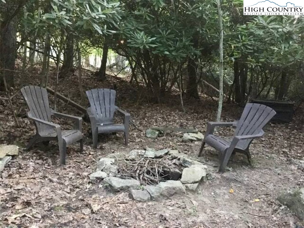 702 Pine Ridge Road Beech Mountain, NC 28604 - Photo 22 of 24 a view of a chairs and fire pit in the backyard