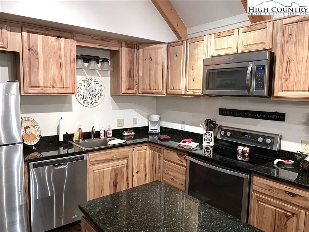702 Pine Ridge Road Beech Mountain, NC 28604 - Photo 7 of 24 a kitchen with stainless steel appliances granite countertop a sink stove and microwave