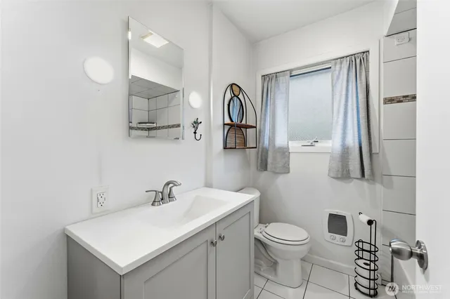 a bathroom with a toilet sink vanity and mirror