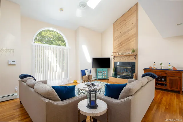a living room with furniture a fireplace and a floor to ceiling window
